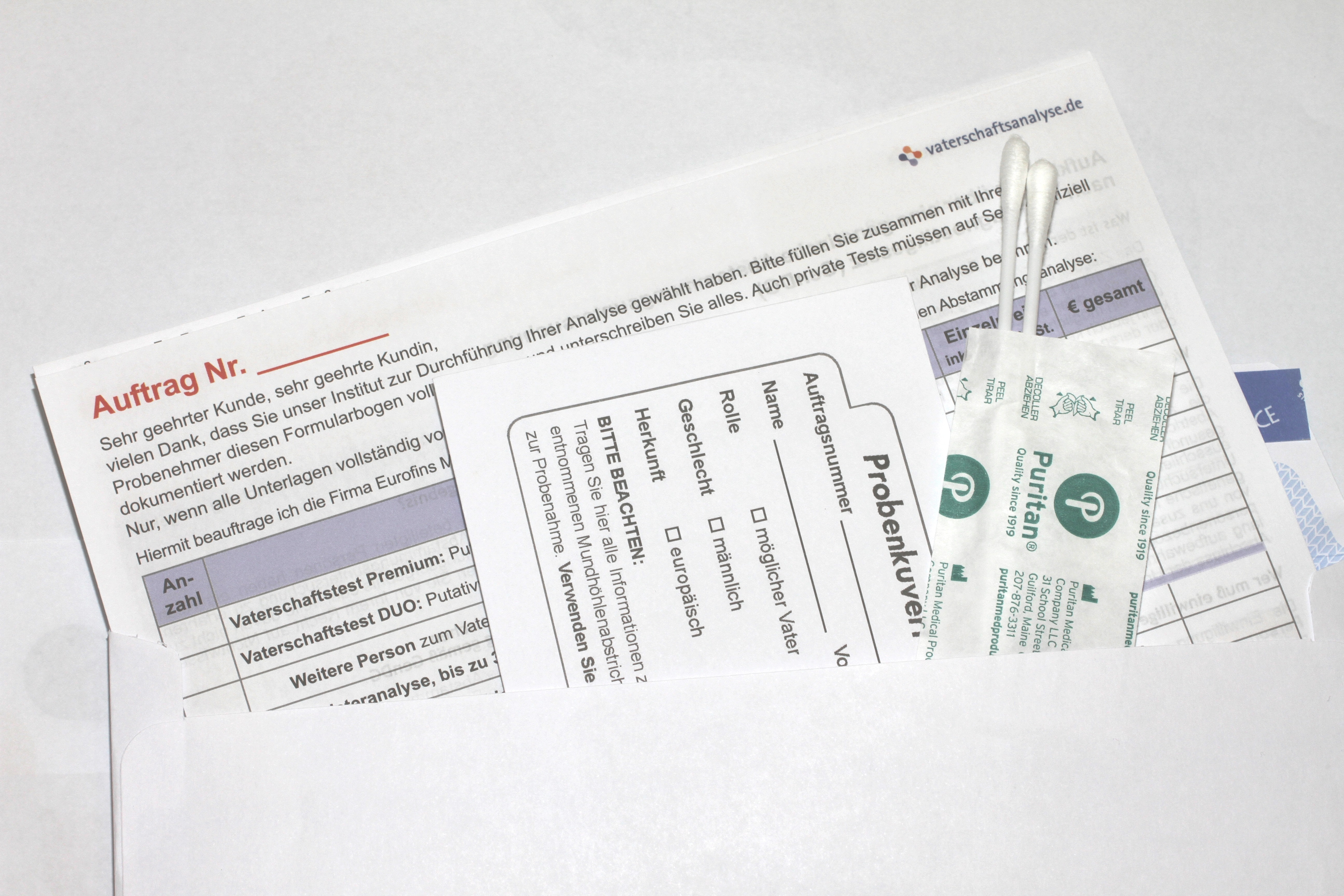 Zettel mit Formular und Wattestäbchen aus einem Umschlag für eine Analyse.