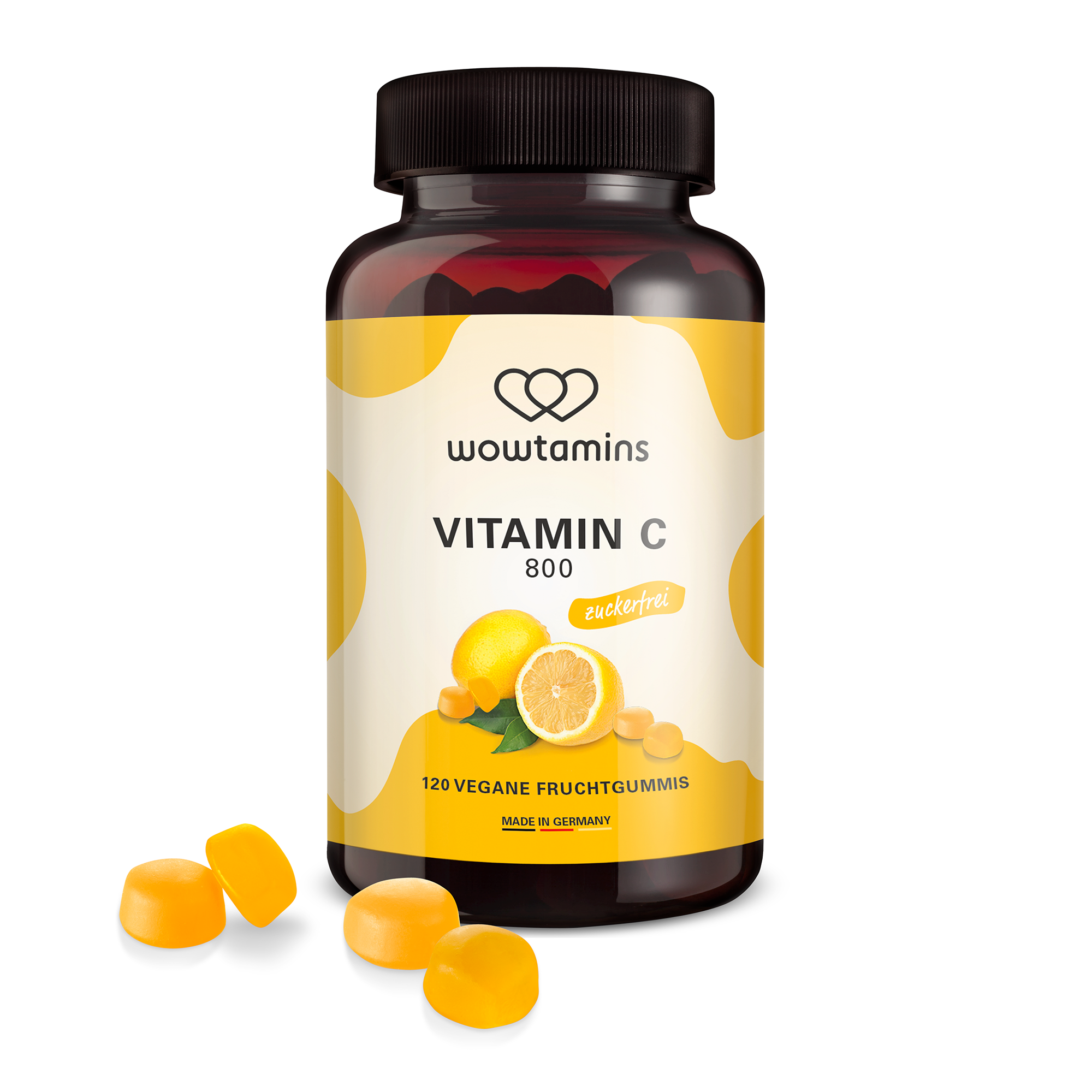 Braunglasflasche mit veganen Fruchtgummis, die Vitamin C enthalten, drei Gummis liegen daneben.