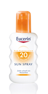 Flasche mit Eucerin Sun Spray SPF 20, weiß mit orangefarbenem Deckel und Beschriftung.