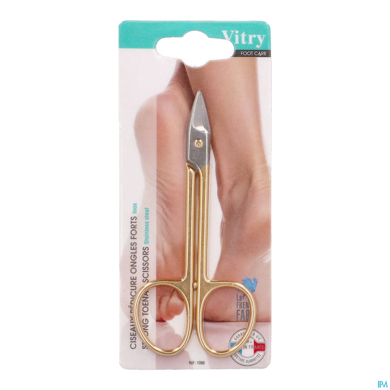 Eine goldene Nagelschere auf einer Verpackung mit einem abgebildeten Fuß im Hintergrund.